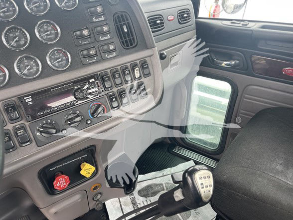 Peterbilt 389 interior dashboard with gauges, control switches, and manual transmission gear lever visible.