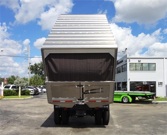 Rear view of a 2014 Freightliner Business Class M2 106 dump truck with raised aluminum dump body, black tailgate latch, and dual rear wheels.