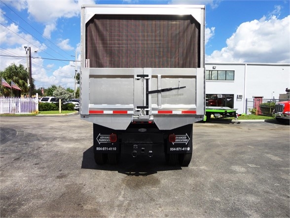 Rear view of a 2014 Freightliner BUSINESS CLASS M2 106 dump truck with tailgate and back gates open in a parking lot.