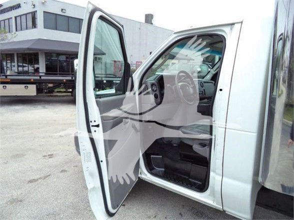 Ford E-450 box truck interior driver-side view with open door, steering wheel and dashboard visible.