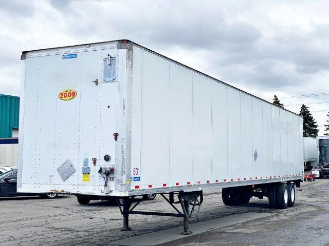 2009 Stoughton dry van trailer showing rear and side panels with a yellow 2009 sticker and various inspection tags.