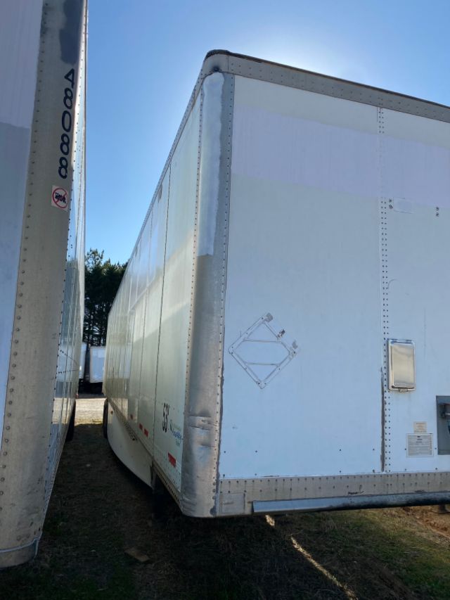 Trailer side and front corner of a 2015 Wabash Duraplate trailer with smooth white exterior and protective corner guards.