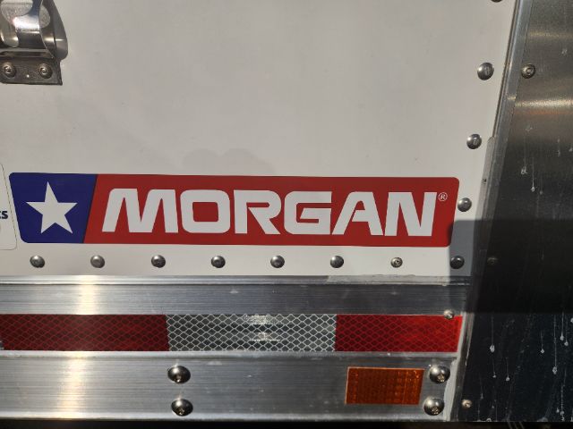 Morgan trailer or truck rear with Morgan logo sticker, riveted aluminum panels, red/amber reflector strip and orange side marker.