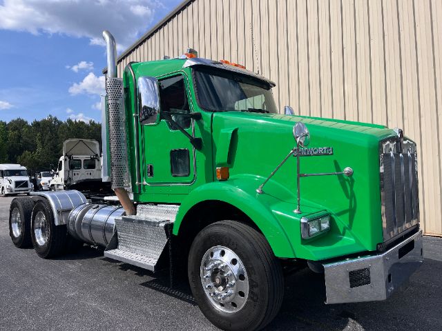 2014 Kenworth T800 conventional daycab truck green exterior side view showing chrome exhaust stack and fuel tanks.