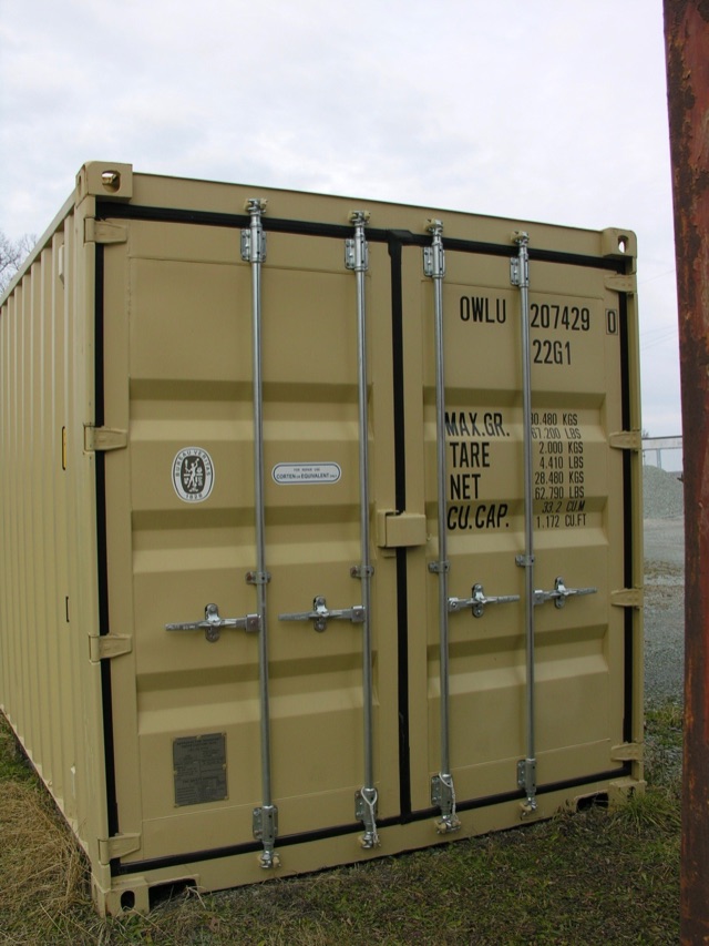 Front view of a beige shipping container with vertical locking bars and labeled port data on the right door.