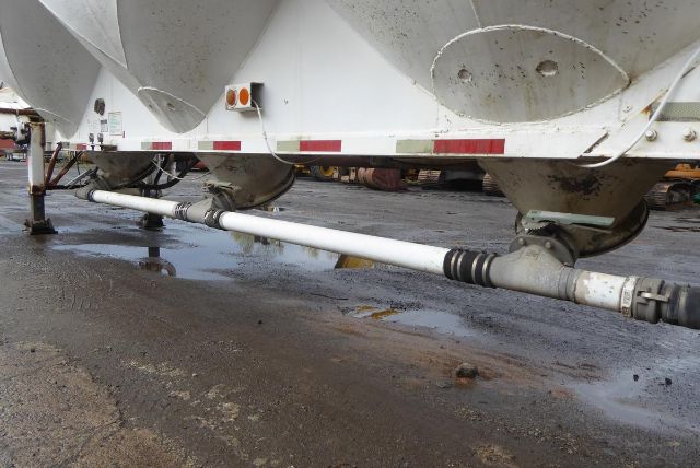 Fruehauf dry bulk trailer undercarriage showing pneumatic hose and drive shaft with white cylindrical crossbar.