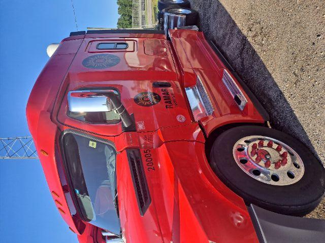 Front-left side of a red Freightliner Cascadia sleeper cab truck with stock number 20005 and RAMAR logo on door.