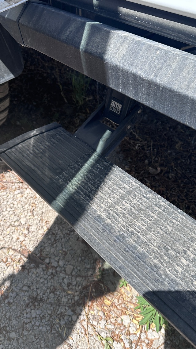 Ford F-550 cab and chassis step with AMI accessories label visible on the frame.