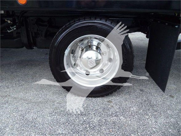 Wheel and tire of a 2023 Chevrolet Silverado 6500HD truck showing shiny steel rim and black tire under a fender.