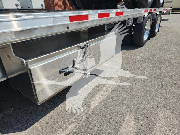 Wabash trailer rear side deck with aluminum storage box under deck and step latch visible.