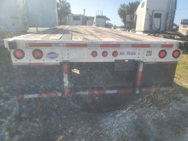 Flatbed trailer rear showing taillights and bumper with Air Ride tag and stickers.