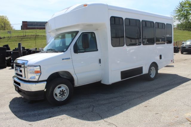 Ford E-450 shuttle bus in white, side windows, front cab, outboard wheels on pavement, stock number 258001JH visible.