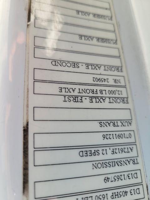 Labels on a Volvo truck door jamb with several lines of text including 'FRONT AXLE - RIG', 'REAR AXLE - SCDOND' and serial-like numbers. The image appears rotated upside down.