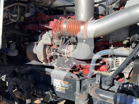 Kenworth T800 engine bay showing turbocharger and red engine components with hoses and belts visible.