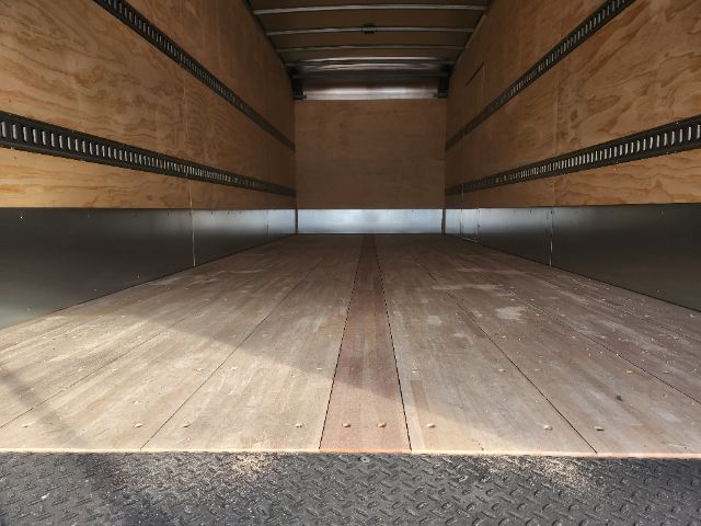 Box truck cargo area showing wooden floor and side walls with metal rails.