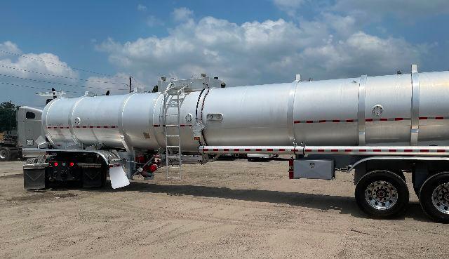 Crude oil tank trailer 2012 Dragon 200BBL aluminum DOT-407 showing cylindrical aluminum tank, ladder, rear wheels, and safety markings.