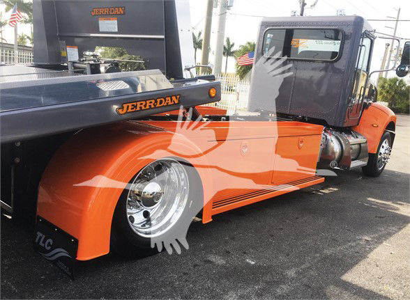 Orange Peterbilt 337 tow truck with lowboy, Jerr-Dan equipment, chrome wheel, cab and sleeper visible.