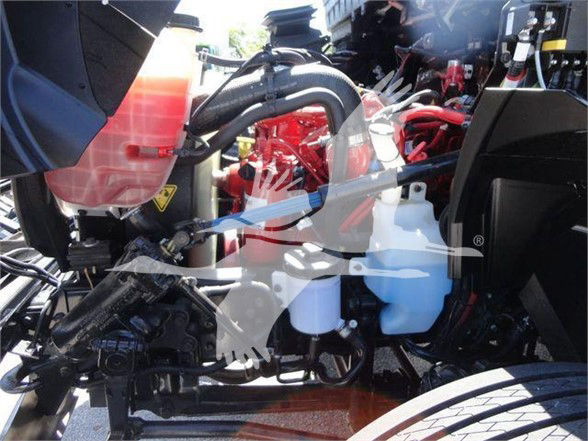 Truck engine bay showing coolant reservoir and hydraulic lines; white semi-opaque coolant reservoir and red engine components in International MV truck