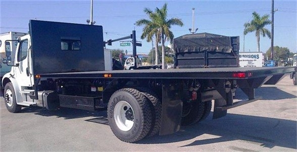 Flatbed truck body with dual rear wheels and extended flatbed showing storage box and equipment, 2024 Advanced Fabricators 20 ft listing.