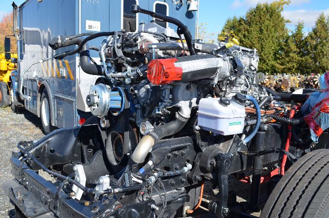Vehicle engine bay of a 2017 Western Star 5700 XE showing exposed engine components, hoses, belts, and a white coolant reservoir.