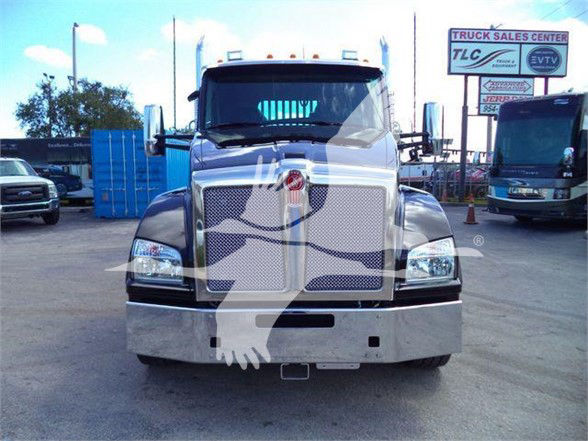 Kenworth T880 front view truck with large chrome grille and bumper. Stock number J68211 visible. The image shows a new tow truck on a dealership lot.