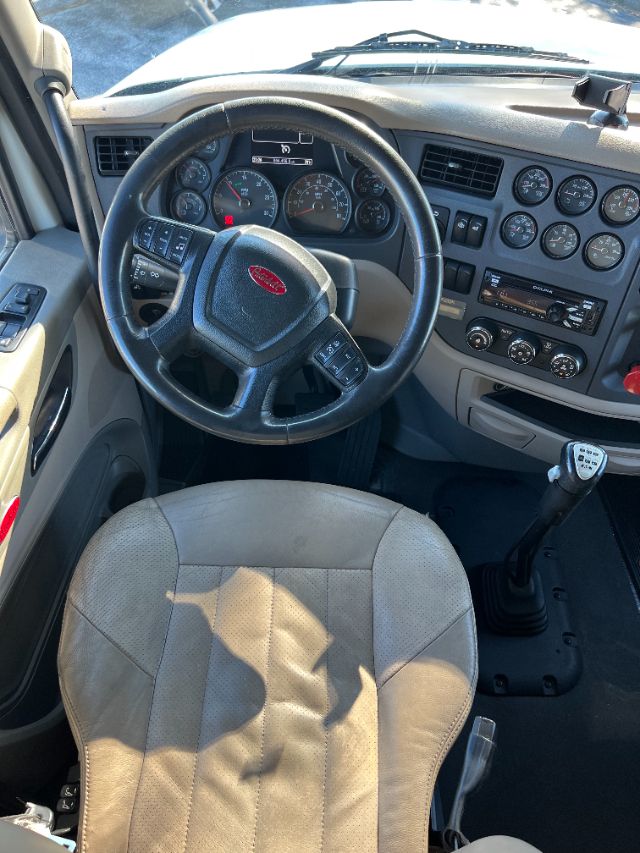 Peterbilt 579 truck interior showing steering wheel, dashboard gauges, and gear shifter.