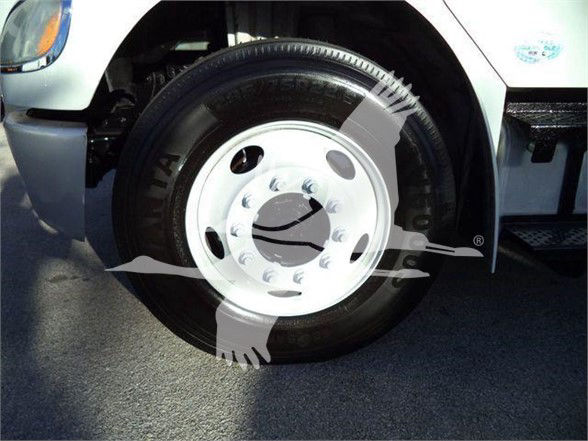 Fleet truck wheel and tire assembly on Freightliner Business Class M2 106 showing white steel wheel and tire sidewall.