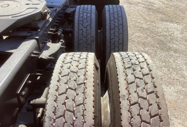 Peterbilt 579 truck rear dual wheels and tires with visible road grime and tread pattern.