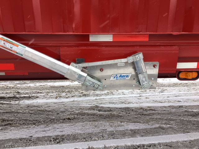 Trailer hitch assembly attached to a red scrap gondola trailer showing Aero brand hardware and support brackets with manual braces.