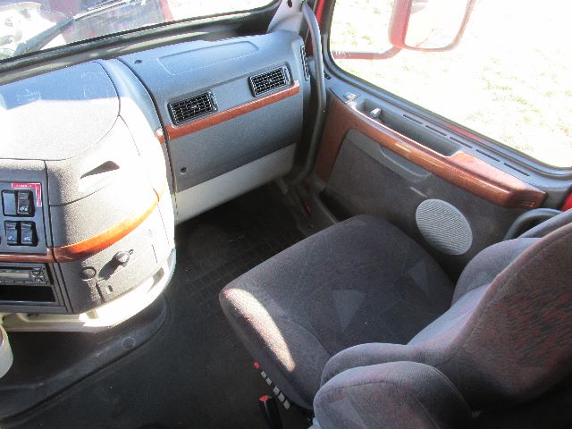  Volvo 780 truck interior showing driver seat, dashboard, and front passenger area with wood trim.