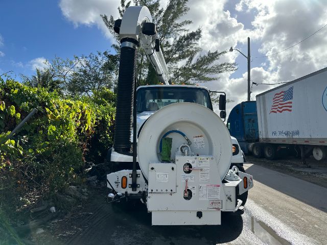 Rear view of a 2014 Freightliner 114SD vacuum truck with mounted hose reel and vacuum intake assembly.