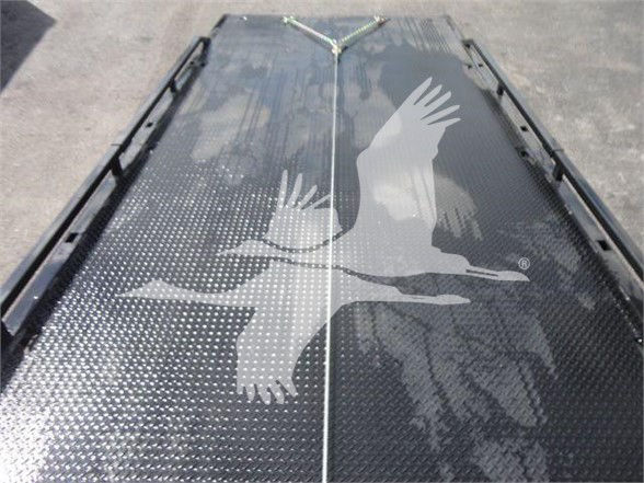 Flatbed truck bed surface with a double-crest seam, textured black with white bird watermark overlay.