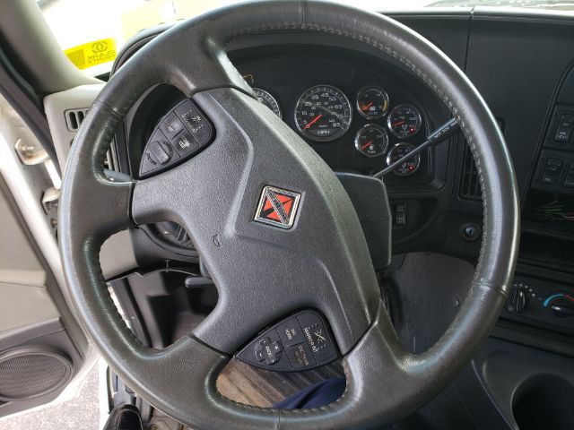 Steering wheel and instrument cluster of a 2015 International PROSTAR truck cab viewed from the driver’s seat.