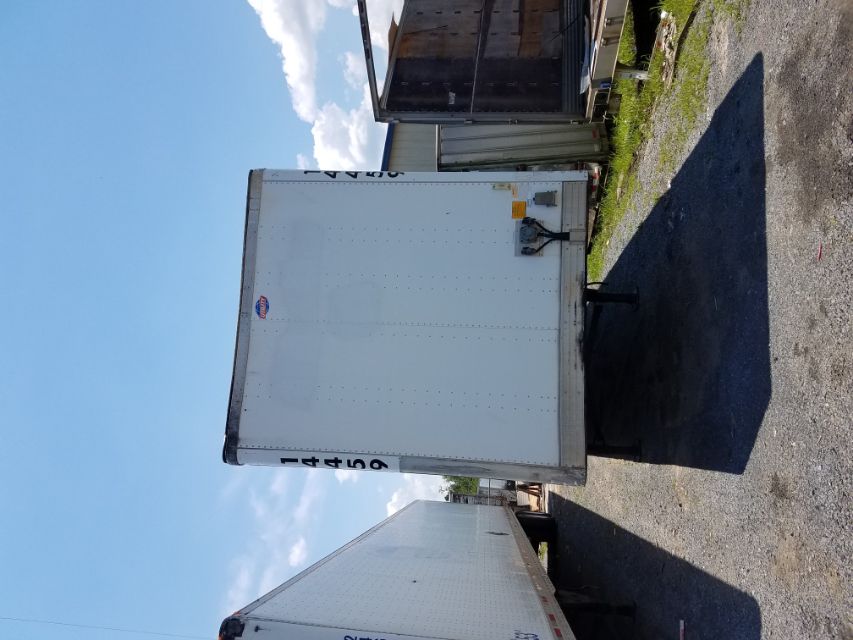 Utility 4000 D-X trailer front view with white box, black front landing gear, and exterior numbers 14459 on both sides.
