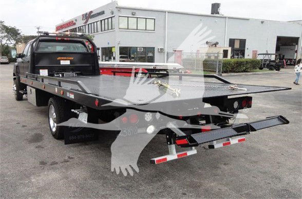 2023 International CV tow truck flatbed with gooseneck and rear loading ramps visible.