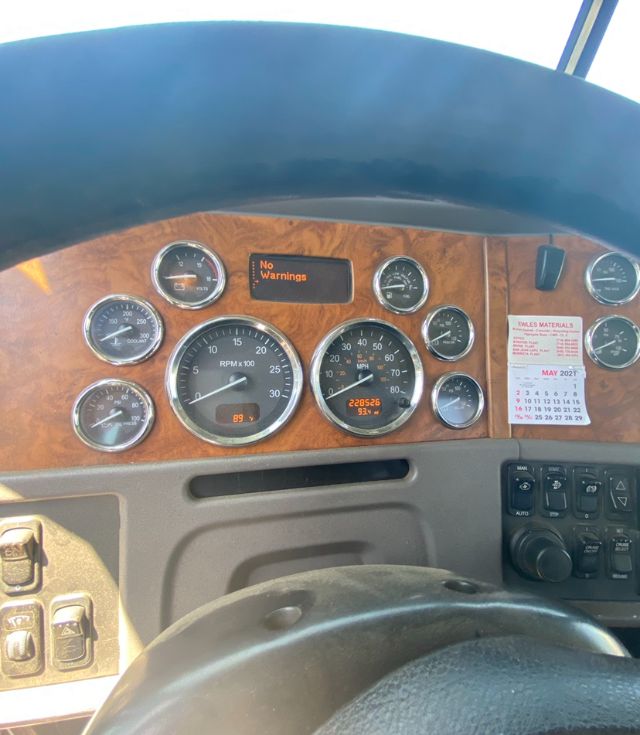 Peterbilt truck dashboard with woodgrain panel showing multiple gauges and a digital display reading 'No Warnings'.