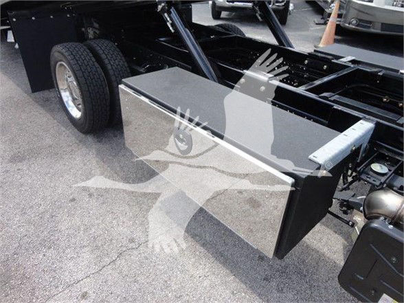 Isuzu NRR truck chassis with metal toolbox mounted near rear, showing dual rear wheels and frame components.