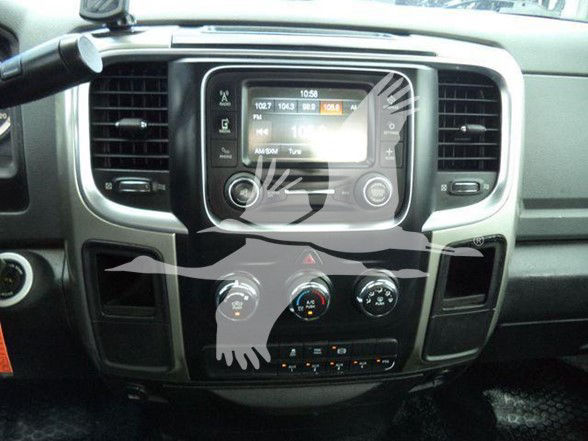 Dashboard center console of a Ram truck showing a touchscreen display with climate controls and radio; surrounding vents and knobs are visible.