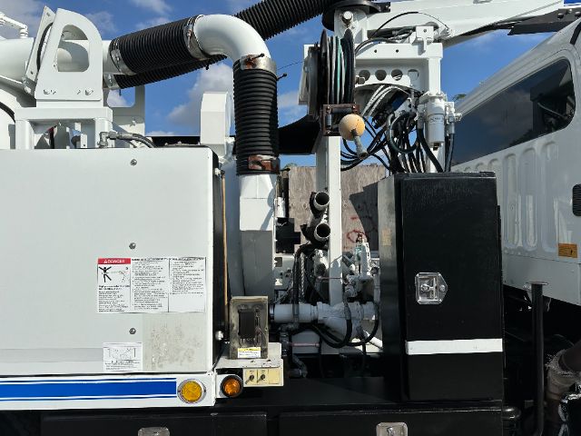 Engine bay of a 2016 Freightliner 108SD showing hoses, electrical panels, and fluid reservoirs.