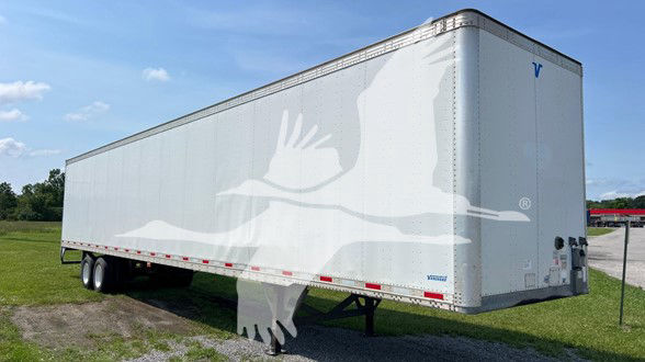 Trailer body with white bird graphic on light gray background, Vanguard/VIP sheet & post trailer, tri-axle, side profile view.
