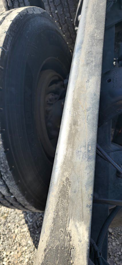 Kenworth T680 front wheel and chassis frame showing tire and dirty frame rail.