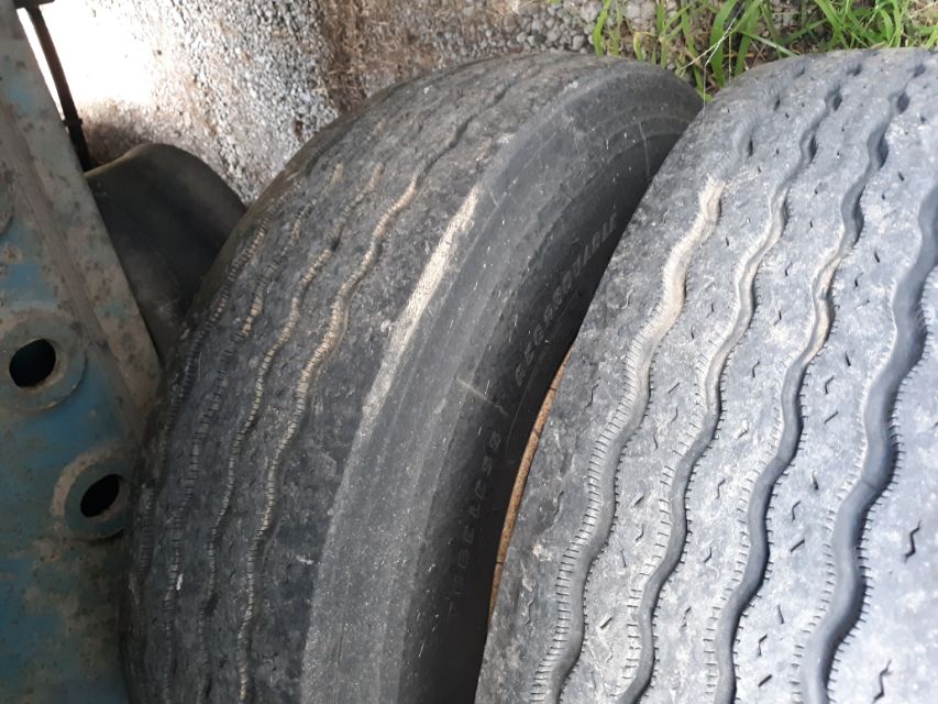 Two stacked tires on a trailer, showing tread patterns and sidewall details.