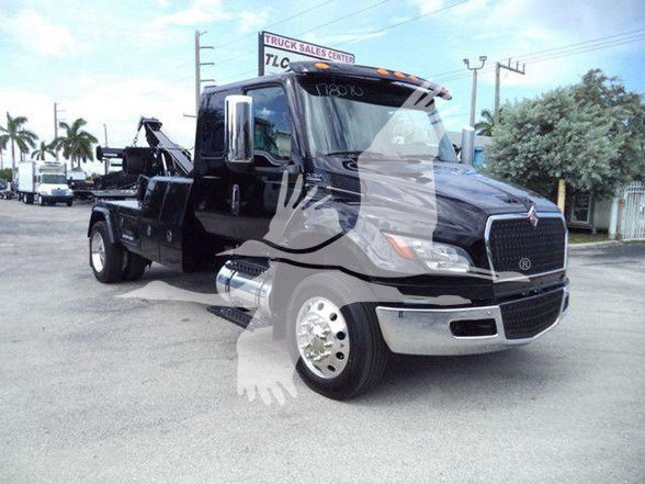 2025 International MV tow truck in black with chrome front grille and dual rear wheels, side mirrors, and a covered cargo area. VIN 3HAEUMMLXSL178070 visible on listing.