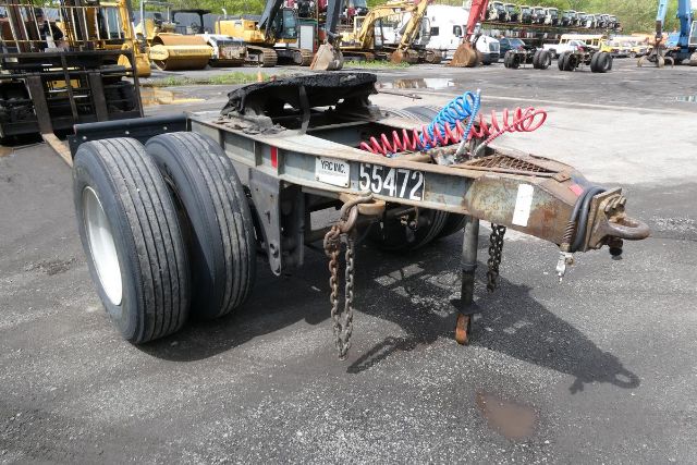Fruehauf ELFI dolly trailer chassis with dual rear axles and coiled air hoses. Visible are license plate area, chains, and hitch components.