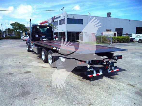 Kenworth T880 flatbed truck in a lot, three rear axles, stock number J68211, new unit.