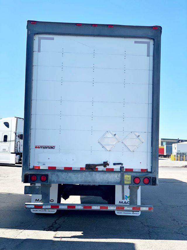 Manac dry van trailer rear view showing closed white cargo doors and reflective tape along the bumper.