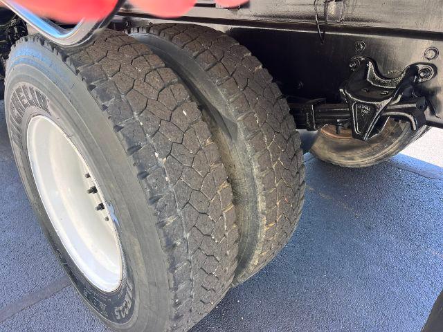 Dual rear tires of a Freightliner M2 106 dump truck showing wheel assembly and suspension components.