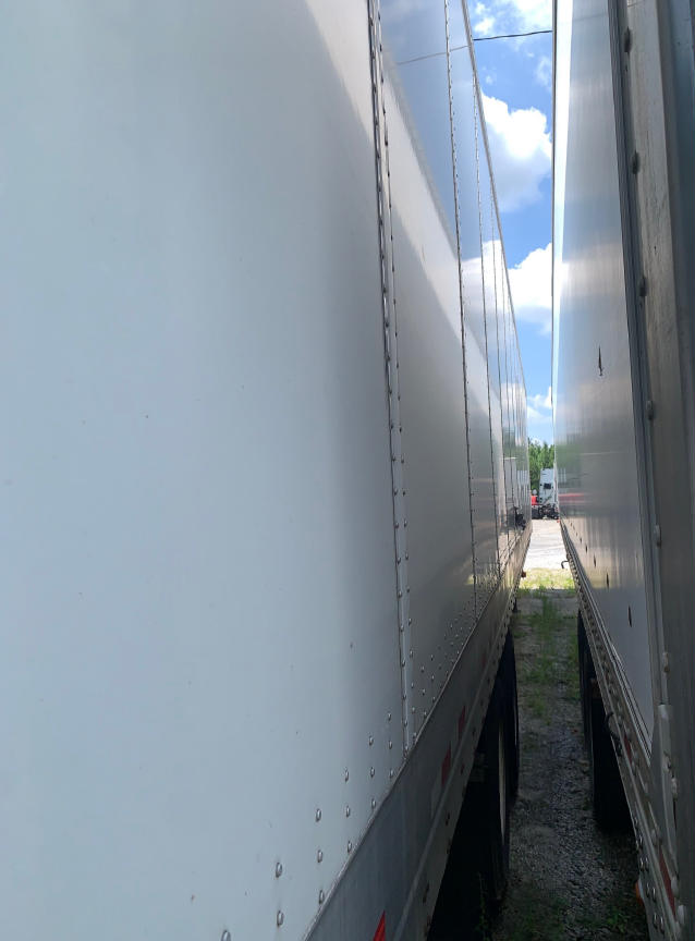 Side view of a 2018 Vanguard VXP trailer showing riveted aluminum panels and gap between two trailers.