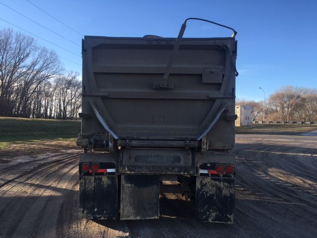 Rear view of a 2012 Trail King ASAHR2-487248 dump trailer with large gray tailgate, dual mud flaps, and taillights on each side.