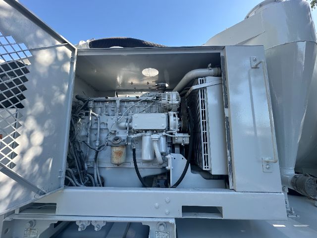 Engine bay of a 2006 Sterling L8500 vacuum truck showing diesel engine with intake manifold, belts, hoses, and radiator visible; side access panel open.